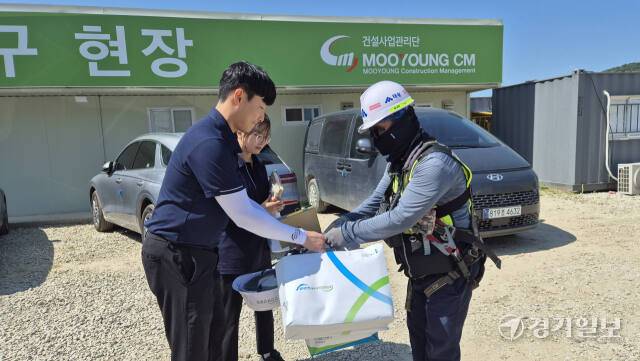 산업안전보건공단 경기지역본부 송기명 과장과 김영은 대리가 쿨토시, 수건 등으로 구성된 쿨키트 78개가 담겨있는 마중물을 현장 안전팀장에게 전달하고 있다. 이대현기자