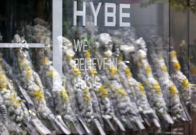 그룹 뉴진스 멤버들이 하이브에 민희진 전 어도어 대표의 복귀를 25일까지 요구한 가운데 지난 23일 서울 용산구 하이브 사옥 앞에 뉴진스 팬들이 보낸 근조화환이 반영되고 있다. /사진=뉴시스