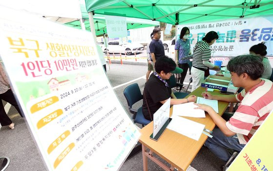 지난 11일 오전 광주 북구 두암3동 행정복지센터 앞 마당에서 구청 직원들과 복지도우미들이 생활안정지원금관련 업무를 하고 있다. 광주 북구 제공, 뉴스1