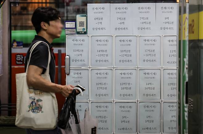 지난 20일 오후 서울 시내의 한 공인중개사 사무실 앞에 아파트 가격 안내문이 붙어 있다. 뉴시스