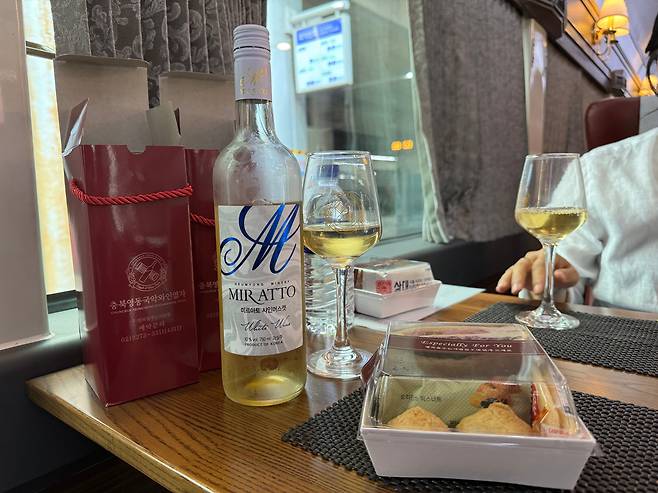 지난 24일 오전 서울역에서 영동역으로 가는 영동 국악와인열차 3호칸 2인석에 충청북도 영동 용산면에서 생산한 '미르아토 샤인머스캣' 화이트 와인과 와인잔, 샌드위치가 놓여있다. /박지윤 기자