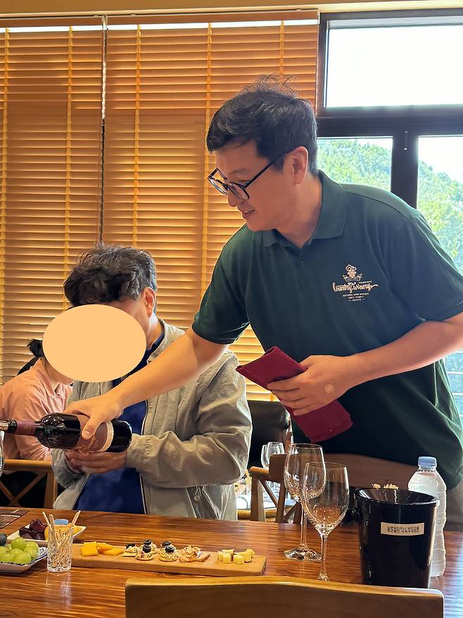 지난 24일 오후 충청북도 영동군 농가형 와이너리 '컨츄리 와인' 시음 공간에서 김덕현 대표가 영동에서 생산한 '컨츄리 캠벨 스위트' 레드 와인을 와인잔에 따르고 있다. /박지윤 기자