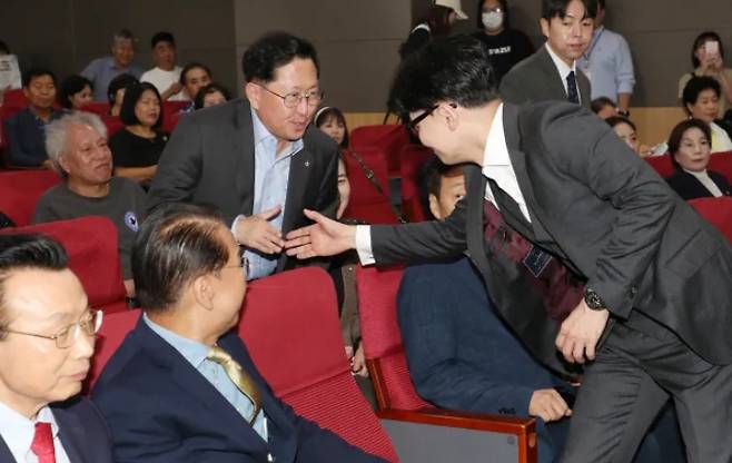 Han Dong-hoon, leader of the People\'s Power Party, shakes hands with PPP lawmaker Yoo Yong-won at a seminar at the National Assembly on September 25. Reporter Park Min-gyu