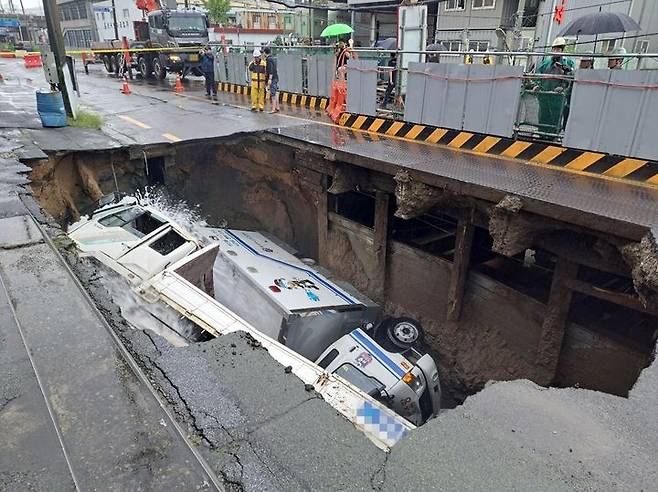 [부산=뉴시스] 권태완 기자 = 지난 21일 오전 부산 사상구 새벽로 인근 도로에서 가로 10m·세로 5m, 깊이 8m 규모의 땅꺼짐이 발생해 차량 두 대가 빠졌다. (사진=부산소방재난본부 제공) 2024.09.26. photo@newsis.com *재판매 및 DB 금지