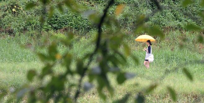 전국적으로 선선한 날씨가 이어지고 있는 20일 전북 전주시 삼천을 찾은 시민이 우산으로 비를 피하며 길을 지나고 있다. 2024.09.20.뉴시스