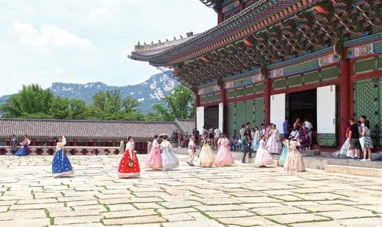 경복궁 근정전 앞에서 기념 사진을 찍고 있는 한복 차림의 외국인 관광객과 시민들의 모습. / 사진:박세나