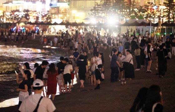 지난 8월 역대 최장 열대야가 이어진 부산시 수영구 광안리해수욕장에 시민들이 붐비고 있다. 연합뉴스