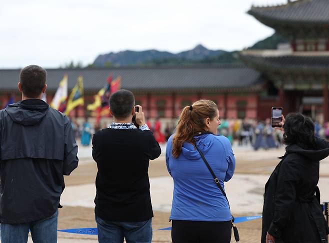 Tourists photograph Gyeongbokgung in Seoul, Saturday. (Yonhap)