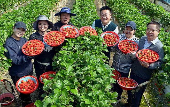 Seasonal farm workers pose for a photo with a farm owner and officials from the National Agricultural Cooperative Federation, commonly known as Nonghyup. [KIM SEONG-TAE]