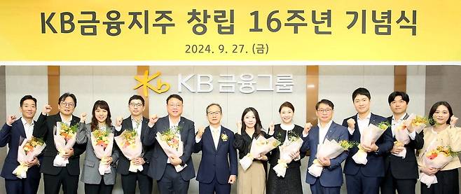 KB금융지주가 27일 서울 여의도 KB국민은행 신관에서 지주 창립 16주년 기념식을 치렀다. 양종희 KB금융 회장(가운데)과 10·20년 장기 근속으로 공로패를 받은 직원들이 기념촬영을 하고 있다.  KB금융