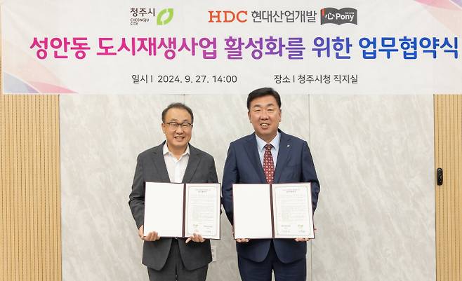 HDC현대산업개발은 27일 청주시와 함께 심포니 작은도서관 건립을 위한 업무협약을 체결했다. 사진은 신왕섭 HDC현대산업개발 실장(왼쪽)과 이범석 청주시장이 기념사진을 촬영하는 모습. /사진=HDC현대산업개발