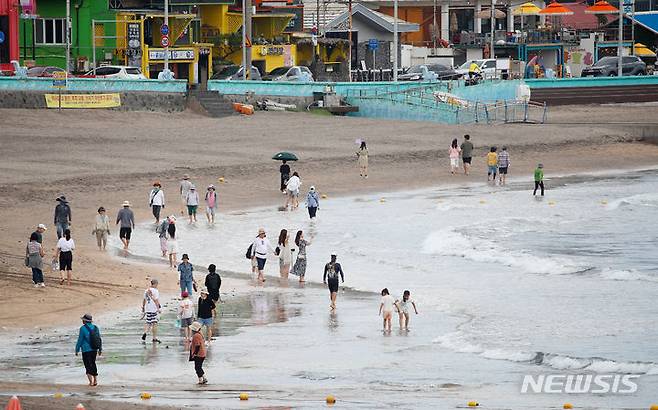 [제주=뉴시스] 우장호 기자 = 제주시 이호테우해수욕장을 찾은 시민과 관광객들이 물놀이 대신 맨발걷기 일종인 어싱을 즐기고 있다. 2024.07.01. woo1223@newsis.com