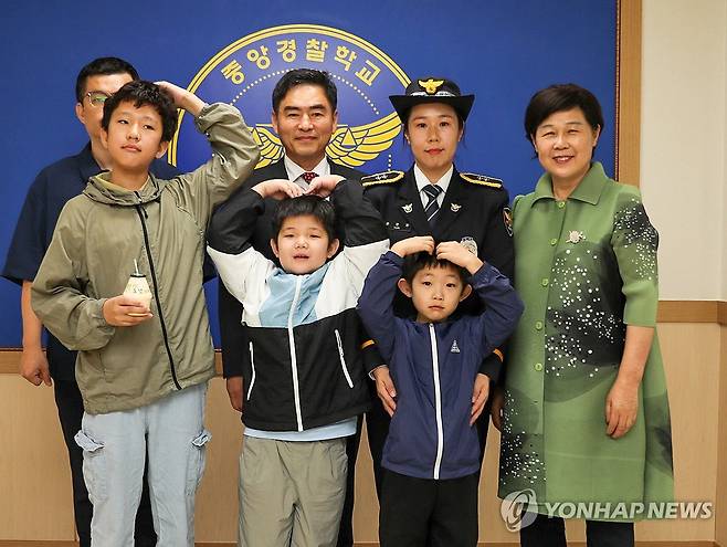 윤석열 대통령, 다자녀 양육 순경 신규 임용 축하 (서울=연합뉴스) 홍해인 기자 = 대통령실은 윤석열 대통령이 27일 신임 경찰관 314기 졸업식에 참석한 윤은정 순경과 그 가족에게 조상명 국정상황실장을 보내 축하 서한과 선물을 전달했다고 밝혔다. 
    윤 순경은 11살, 8살, 6살 세 아들의 어머니로 아이들을 키우며 경찰관 준비를 병행해 이번에 신임 경찰관으로 첫발을 내디뎠다. 사진은 윤 순경 가족과 조상명 국정상황실장(뒷줄 가운데). 2024.9.27 [대통령실 제공. 재판매 및 DB 금지] hihong@yna.co.kr