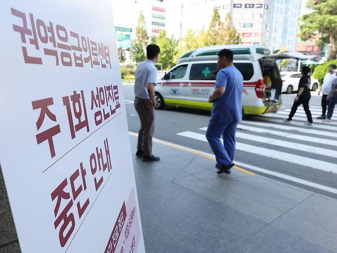 지난 27일 오후 서울의 한 대형 병원 응급의료센터 앞에 주 1회 성인 진료를 중단한다는 안내문이 놓여 있다. /연합뉴스