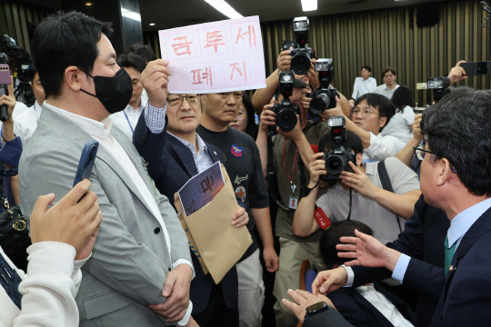 지난 24일 국회에서 열린 더불어민주당 금투세 관련 당내 정책토론회에서 개인투자자 단체인 한국주식투자자연합회(한투연) 회원들이 토론 방청을 막는 것에 대해 항의하며 금투세 폐지를 촉구하고 있다. 연합뉴스