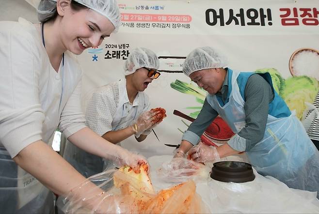 소래포구축제에 참가한 인천공항 외국인 환승객들이 박종효 남동구청장(오른쪽)과 함께 김장 담그기 전통문화 체험을 하고 있다. 인천 남동구 제공