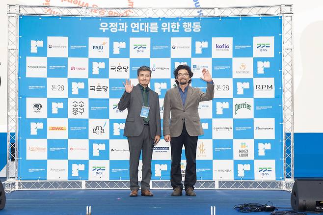 The 16th DMZ International Documentary Film Festival director Chang Hae-rang, left, and deputy director Oh Jung-hoon pose for a photo during the festival's blue carpet event held before the main opening ceremony, held at the Imjingak Pyeonghwa-Nuri Open-air Stage in Paju, Gyeonggi, on Thursday. [DMZ DOCS]