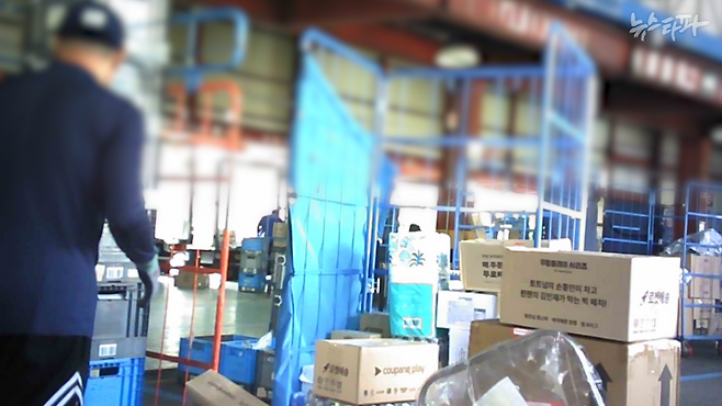 지난 8월 23일 촬영한 쿠팡 제주2캠프의 모습. 배송기사들이 상품 분류 작업을 하고 있다. 롤테이너(쿠팡에서 쓰는 이동형 배송 케이지) 안에 여러 배송구역의 상품들이 혼재돼 있기 때문에 기사들이 직접 분류하지 않으면, 배송을 할 수 없다.&nbsp;