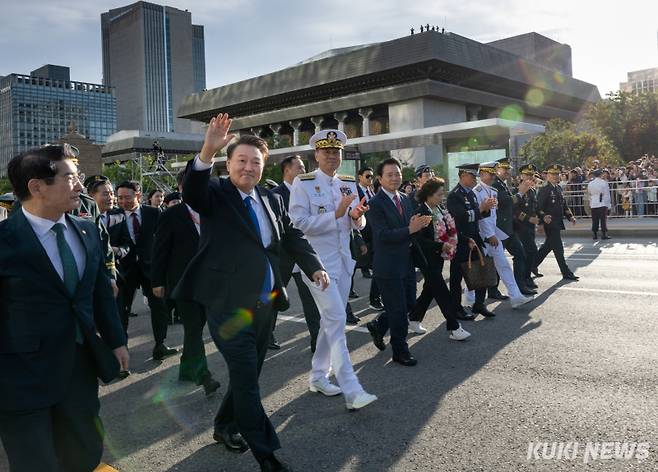 <yonhap photo-4889=""> 윤석열 대통령, 국군의날 국민과 함께 행진윤석열 대통령이 1일 서울 광화문 일대에서 열린 건군 76주년 국군의날 시가행진 중 국민과 함께 광화문 월대를 향해 행진하며 손흔들어 인사하고 있다. (대통령실 제공)</yonhap>