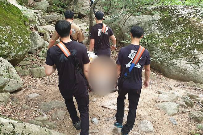 들것에 환자를 옮겨 하산하는 산악구조대원들 [강원특별자치도소방본부 환동해특수대응단 제공. 재판매 및 DB 금지]