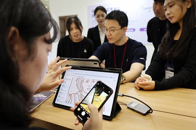 서울 강남구 코엑스에서 열린 2024 에듀테크 코리아 페어에서 관람객들이 AI 디지털교과서 프로토타입을 살펴보고 있다. [연합]