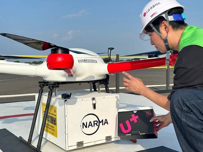 LG유플러스가 국내 통신사 최초로 드론을 활용해 섬 지역에 스마트폰을 배송하는 ‘스마트폰 드론 배송’ 서비스를 시행한다. 사진은 LG유플러스 직원이 제주도에 구축된 드론 배송 거점에서 드론에 스마트폰을 싣는 모습. LG유플러스 제공