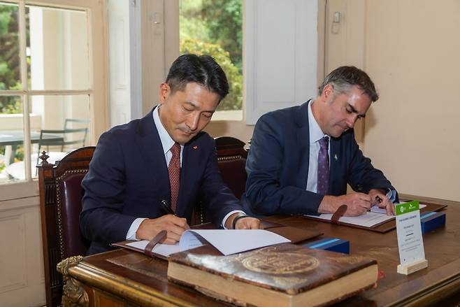 Kim Wone-kee (left), CEO of SK Enmove, and Pablo Altimiras, chief of SQM's iodine plant nutrition division, sign a heads of agreement for the supply of iodine in Santiago, Chile, Tuesday. (SK Innovation)