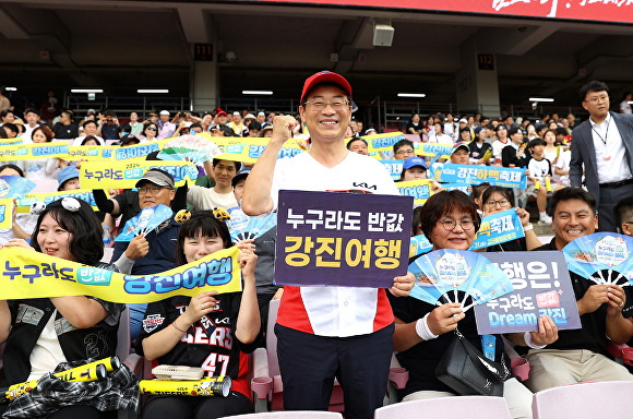 전라남도 강진군 관계자들이 야구장에서 반값 강진여행 관련 배너와 현수막을 들고 있다. [사진=강진군]