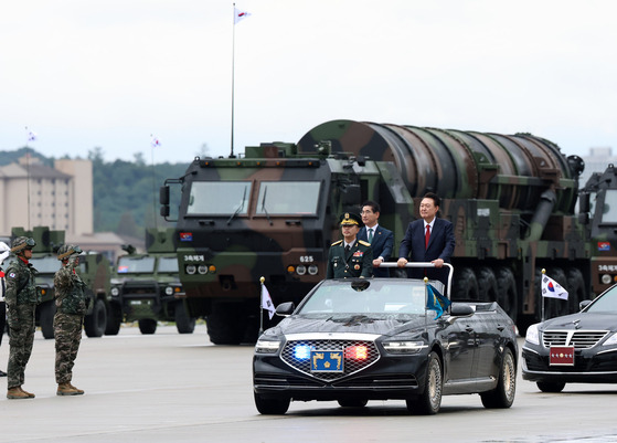 President Yoon Suk Yeol, right, and Defense Minister Kim Yong-hyun pass by a transporter erector launcher carrying Korea’s secretive Hyunmoo-5 ballistic missile during a ceremony marking the 76th Armed Forces Day at Seoul Air Base in Seongnam, Gyeonggi, Tuesday. [PRESIDENTIAL OFFICE]