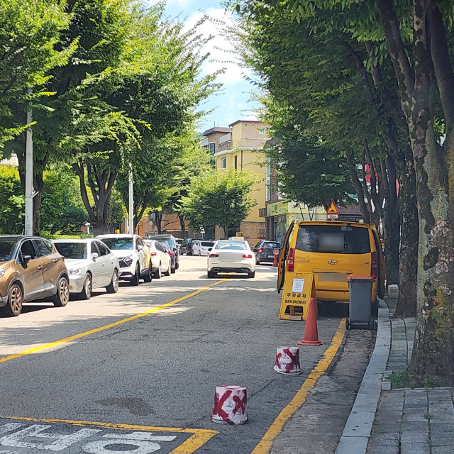 4일 성남시 분당구 한 주택가 앞 도로에 주차를 하지 못하도롯 상가에서 내놓은 페인트통과 라바콘 등이 놓여져 있다. 한준호기자