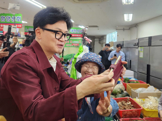 한동훈 국민의힘 대표가 5일 부산 금정구 남산시장에서 열린 ‘행복한 남산 금정애(愛) 와야제‘ 축제 현장을 방문해 윤일현 금정구청장 후보의 지지를 호소하며 시민과 함께 셀카를 찍고 있다. 뉴시스