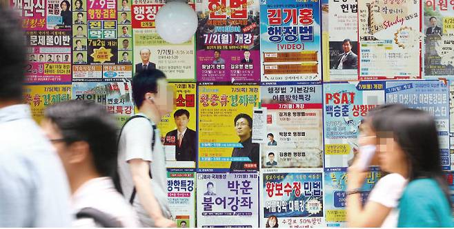 2007년 7월 5일 로스쿨법이 국회를 통과하던 날, 서울 신림동 고시촌에서 고시생들이 법률 학원 전단지들을 뒤로한 채 발길을 재촉하고 있다. [동아DB]