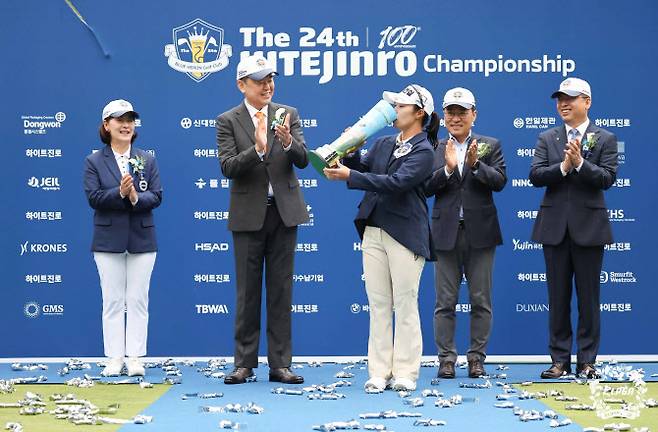 김수지(가운데)가 6일 경기 여주시 블루헤런 골프클럽에서 열린 KLPGA 투어 메이저 대회 하이트진로 챔피언십을 제패한 뒤, 전통에 따라 우승 트로피에 맥주를 담아 마시고 있다.(사진=KLPGT 제공)