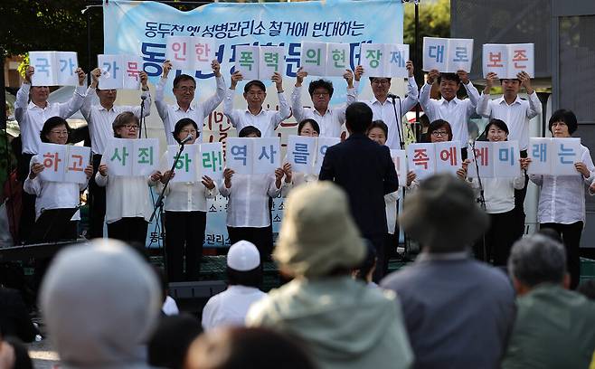 ‘6.15합창단’이 공연을 마친 뒤 글귀가 적힌 악보를 들어 보이고 있다.