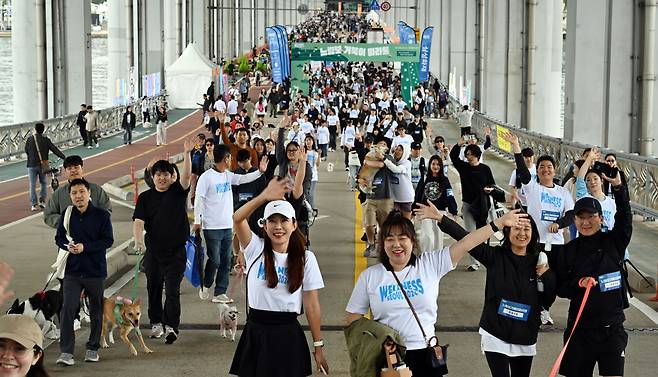 Participants of the Slow Marathon with Pets and their companion pets walk along the Jamsu Bridge -- a submersible bridge connecting Yongsan and Seocho -- on Sunday. (Park Hae-mook/The Korea Herald)