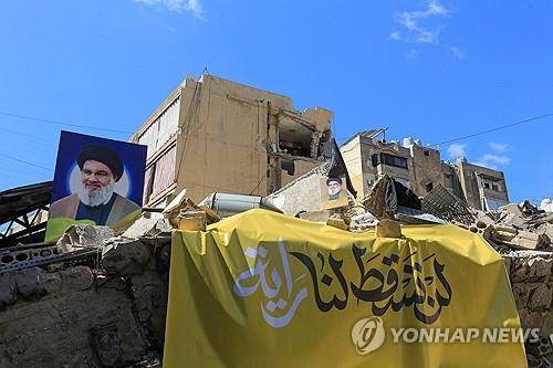 이스라엘 공습으로 무너진 베이루트 남부 건물에 달린 나스랄라의 초상화  [AFP=연합뉴스 자료사진 재판매 및 DB금지]
