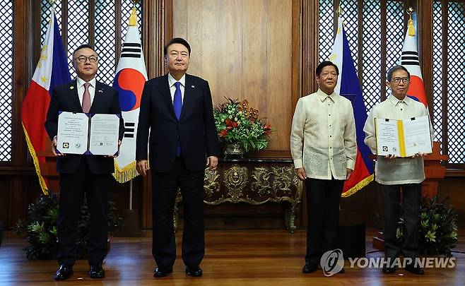 한·필리핀 바탄 원전 건설 재개 타당성 조사 MOU (마닐라=연합뉴스) 진성철 기자 = 황주호 한국수력원자력 사장과 라파엘 로띨리야 필리핀 에너지부 장관이 7일 오전(현지시간) 필리핀 마닐라 말라카냥 대통령궁에서 윤석열 대통령과 페르디난드 마르코스 필리핀 대통령이 임석한 가운데 한·필리핀 바탄 원전 건설 재개 타당성 조사 협력에 관한 양해각서(MOU)를 교환한 뒤 기념촬영을 하고 있다. 2024.10.7 zjin@yna.co.kr