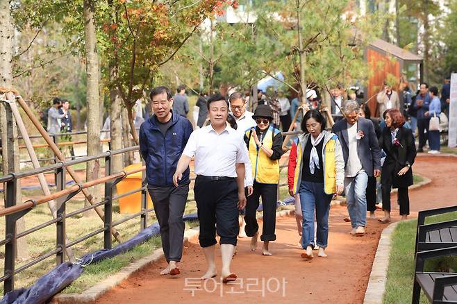 7일 개장식을 마치고 시민들과'백운밸리 연결녹지 황톳길' 맨발 걷기를 하고 있다.[사진=의왕시]