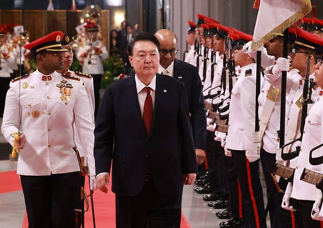 President Yoon Suk Yeol (center, front) and Singaporean President Tharman Shanmugaratnam (center, second row) enter the Parliament House of Singapore as Yoon was on a state visit to the Southeast Asian country on Tuesday. (Yonhap)