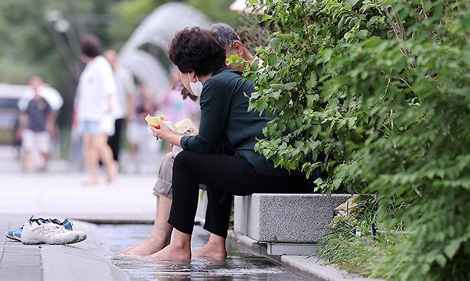 지난 9월 9일 서울 광화문광장에서 시민들이 신발을 벗은채 더위를 식히고 있다. 뉴스1