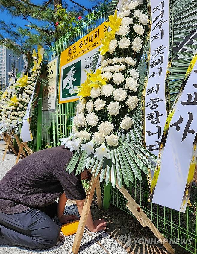 "지켜주지 못해 죄송합니다" 심미영 선생님의 동료 교사가 2023년 9월 8일 학교 앞에 놓인 추모 화환 앞에서 오열하고 있다. [연합뉴스 사진]