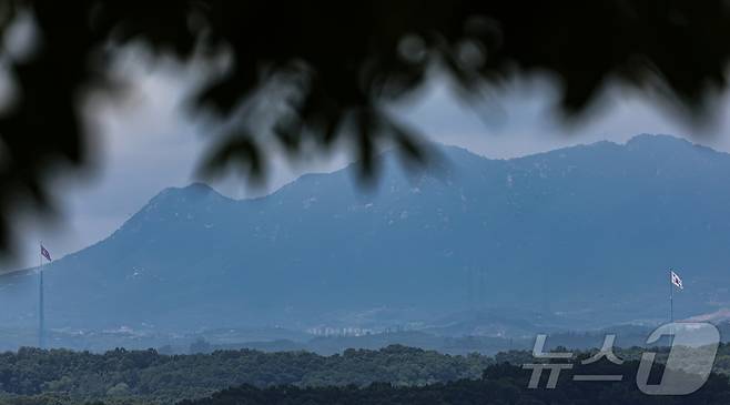 북한이 10번째 대남 오물풍선을 살포한 24일 경기 파주시 접경지역에서 바라본 비무장지대(DMZ) 내 남한 대성동 마을 태극기(오른쪽)와 북한 기정동 마을 인공기(왼쪽)가 펄럭이고 있다. 2024.7.24/뉴스1 ⓒ News1 김도우 기자