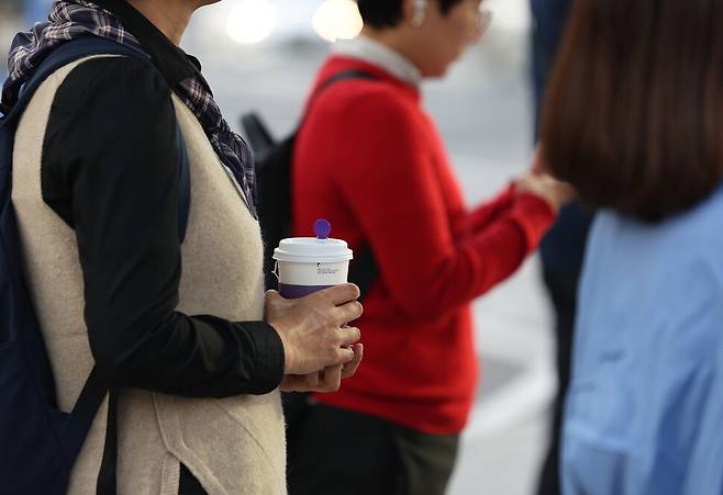 절기상 찬 이슬이 맺히기 시작한다는 한로인 8일 오전 서울 종로구 광화문광장 인근에서 한 시민이 음료를 들고 있다. 연합뉴스