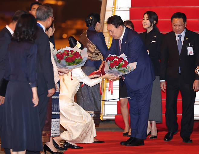 아세안 정상회의에 참석하는 윤석열 대통령과 김건희 여사가 9일(현지시간) 라오스 비엔티안 왓타이 국제공항에 도착해  꽃다발을 받고 있다. 연합뉴스