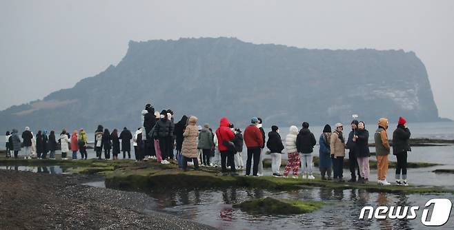 제주 서귀포시 성산읍 광치기해변에서 시민들이 성산일출봉을 바라보며 새해 첫 일출을 기다리고 있다. 2023.1.1/뉴스1 ⓒ News1 오현지 기자