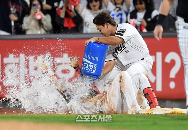 KT 심우준(아래)이 9일 수원 KT위즈파크에서 열린 2024 KBO리그 LG와의 준플레이오프 4차전 연장 11회말 2사 만루 상황에서 끝내기 내야안타를 치자 강백호가 물을 뿌리며 축하하고 있다. 수원 | 박진업 기자 upandup@sportsseoul.com