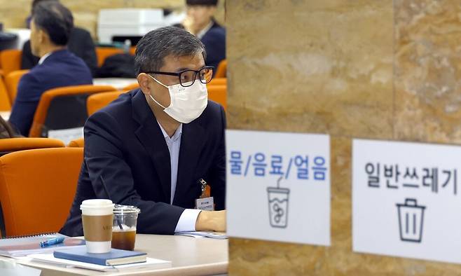 황인수 진실화해위 조사1국장이 10일 오전 서울 여의도 국회에서 열린 행정안전위원회 국정감사에서 신분확인을 위해 마스크를 벗어달라는 의원들의 요구를 거부하다 퇴장당해 국정감사장 밖 공무원 대기석에 앉아 있다. 윤운식 선임기자 yws@hani.co.kr