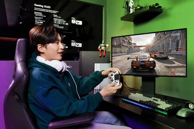LG디스플레이 모델이 27인치 480헤르츠(㎐) OLED 게이밍 모니터로 게임을 하고 있다. LG디스플레이 제공