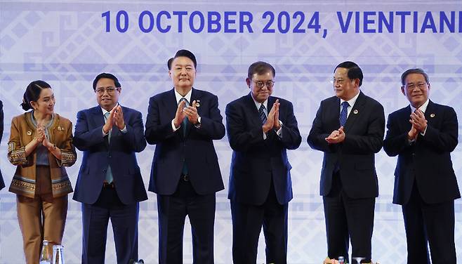 Korean President Yoon Suk Yeol, center left, Japanese Prime Minister Shigeru Ishiba, center right, Chinese Premier Li Chang, right, and leaders of Asean nations pose for a commemorative photo during the Asean plus three summit at a hotel in Vientiane, Laos, Thursday. Yoon and Ishida later held their first bilateral talks. [JOINT PRESS CORPS]