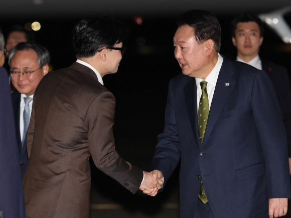 윤석열 대통령, 국민의힘 한동훈 대표와 악수 - 윤석열 대통령이 11일 성남 서울공항에서 필리핀, 싱가포르 국빈 방문 및 라오스 아세안 정상회의를 마치고 귀국하며 마중 나온 국민의힘 한동훈 대표와 악수하고 있다.  연합뉴스